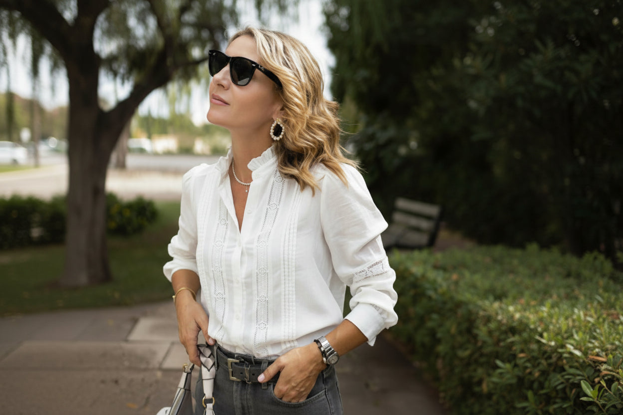 Woman wearing a white blouse with lace details outdoors