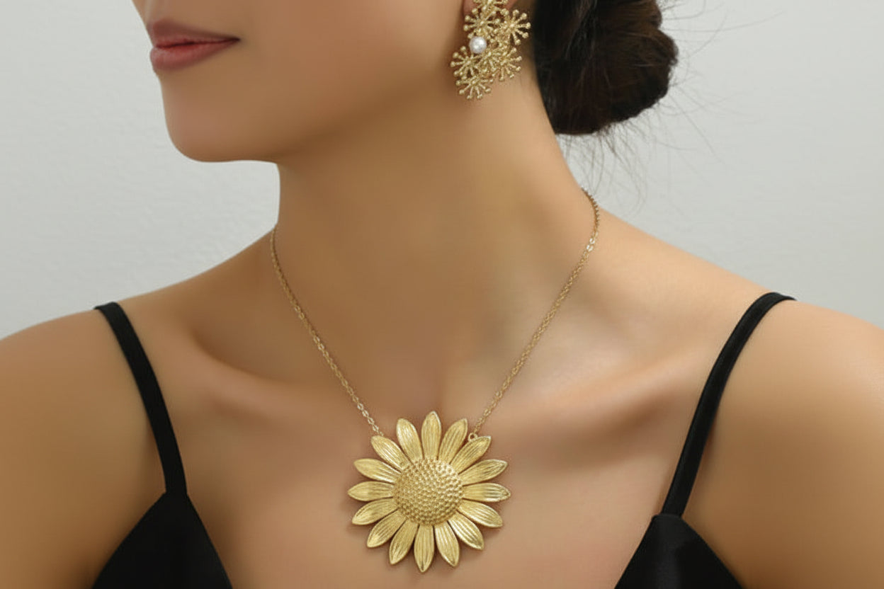 Gold necklace and earrings on a model against a neutral background