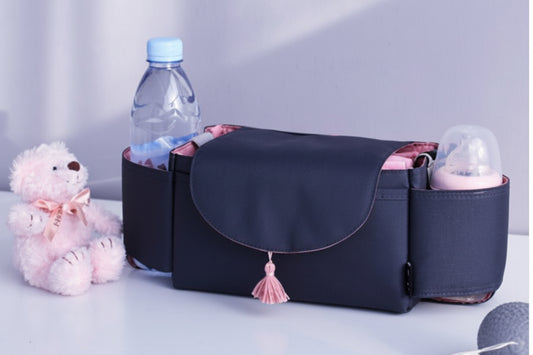 Black diaper bag with baby items on a light background