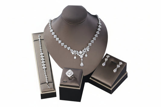 Jewelry set including necklace, earrings, and ring on a mannequin bust with branded boxes.