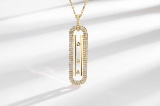 Gold necklace with a rectangular pendant on a light background
