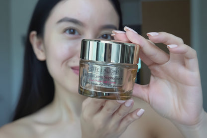 Estée Lauder Revitalizing Supreme+ Youth Power Soft Crème Moisturizer jar held by a person.