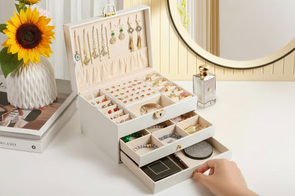 Open jewelry box with various jewelry items on a table.
