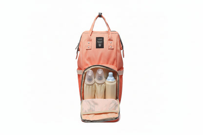 Pink backpack with baby bottles and items inside on a white background