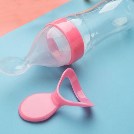 Pink baby bottle with nipple on a blue and pink background