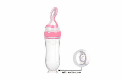 Pink and clear baby bottle with suction cup on a white background