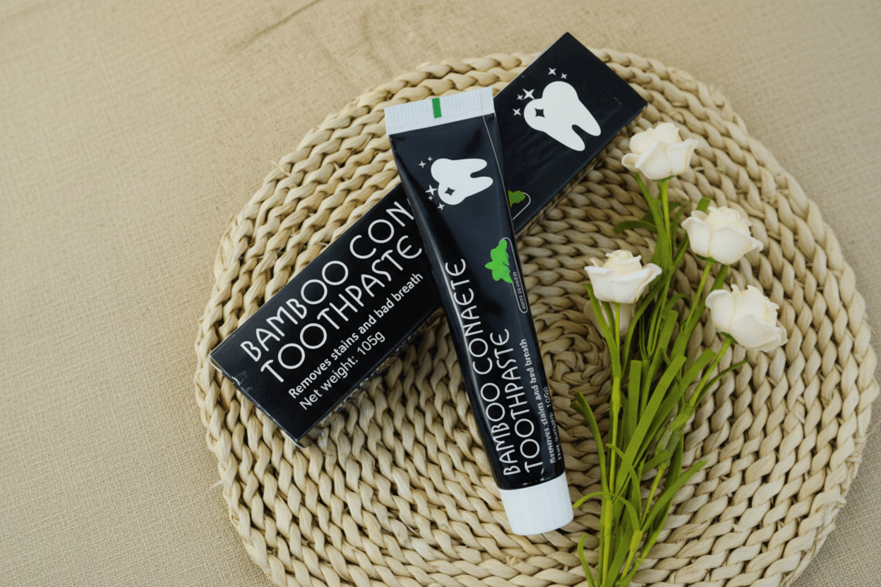 Bamboo Confete toothpaste with packaging on a woven mat with flowers.