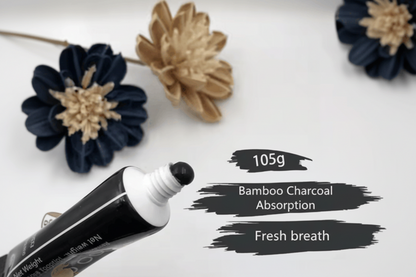 Bottle of mouthwash with text highlighting bamboo charcoal absorption and fresh breath benefits, placed on a surface with decorative flowers.