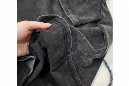 Close-up of a dark gray textured fabric with a hand holding it.