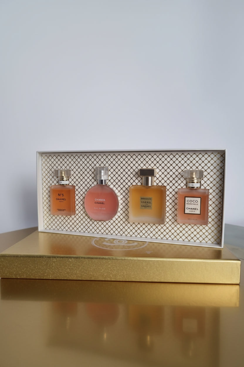 Set of four perfume bottles in a decorative box on a light gray background