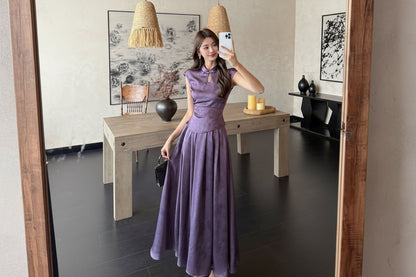 Woman in a purple dress taking a selfie in a modern living room.