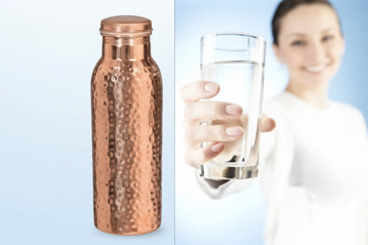 Copper water bottle with a person holding a glass of water in the background
