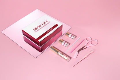 Eyebrow care set with tools and products on a pink background