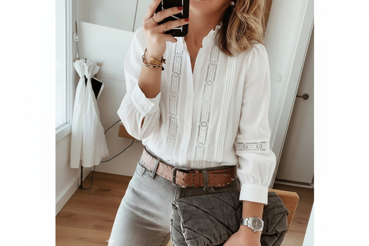 Person wearing a white embroidered blouse with gray pants in an indoor setting.