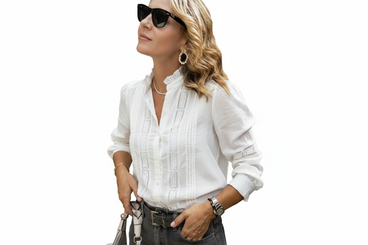 Woman wearing a white blouse with lace details on a white background