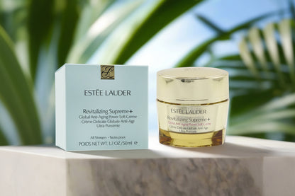 Estée Lauder Revitalizing Supreme+ cream jar and box on a blurred natural background