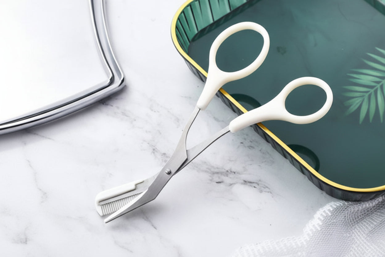 Pair of white-handled scissors on a marble surface with a green cutting board in the background.