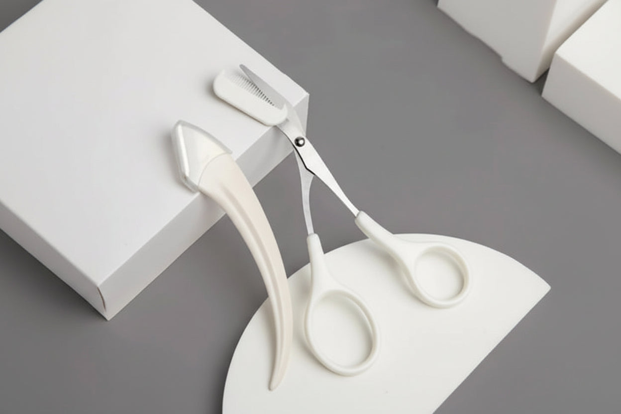 White scissors and hairbrush on a gray surface with a white box.