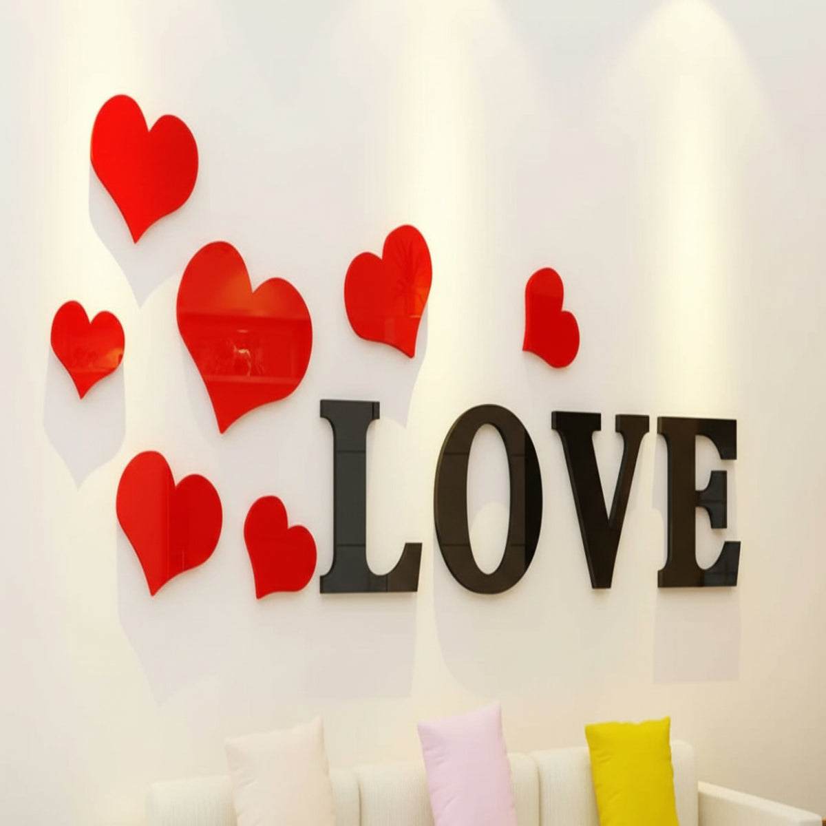 Decorative wall with red hearts and 'LOVE' letters above a white sofa with colorful cushions.