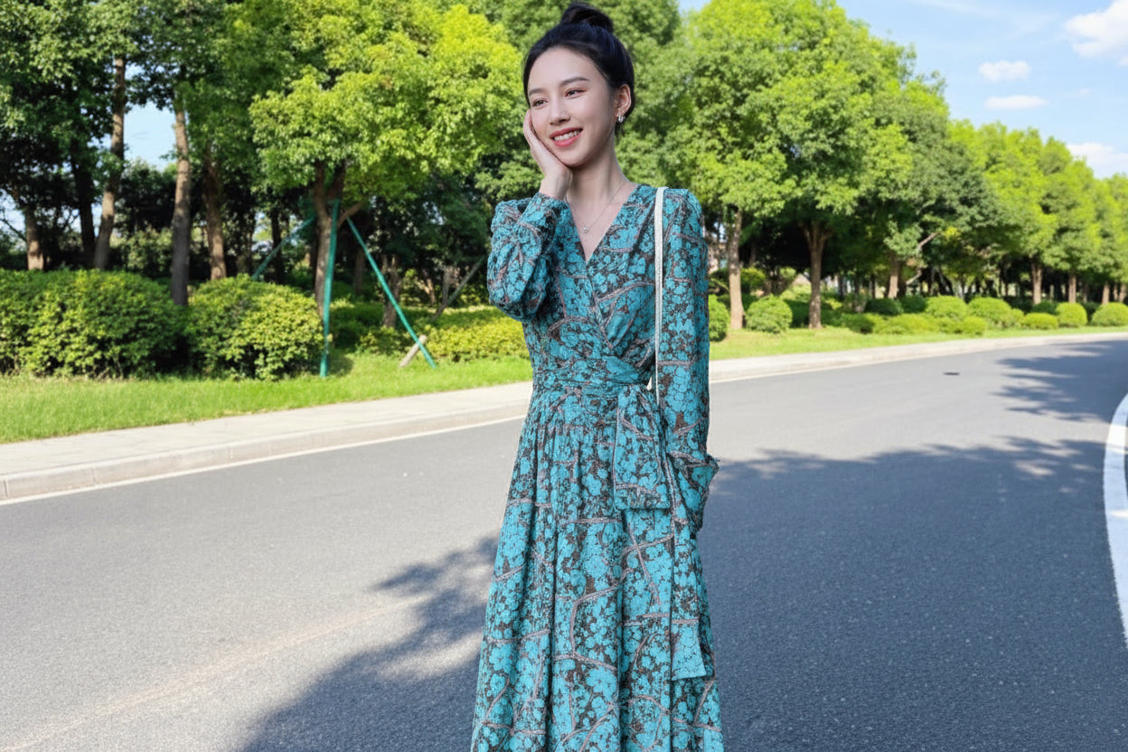 Woman in a green dress standing on a road with trees in the background