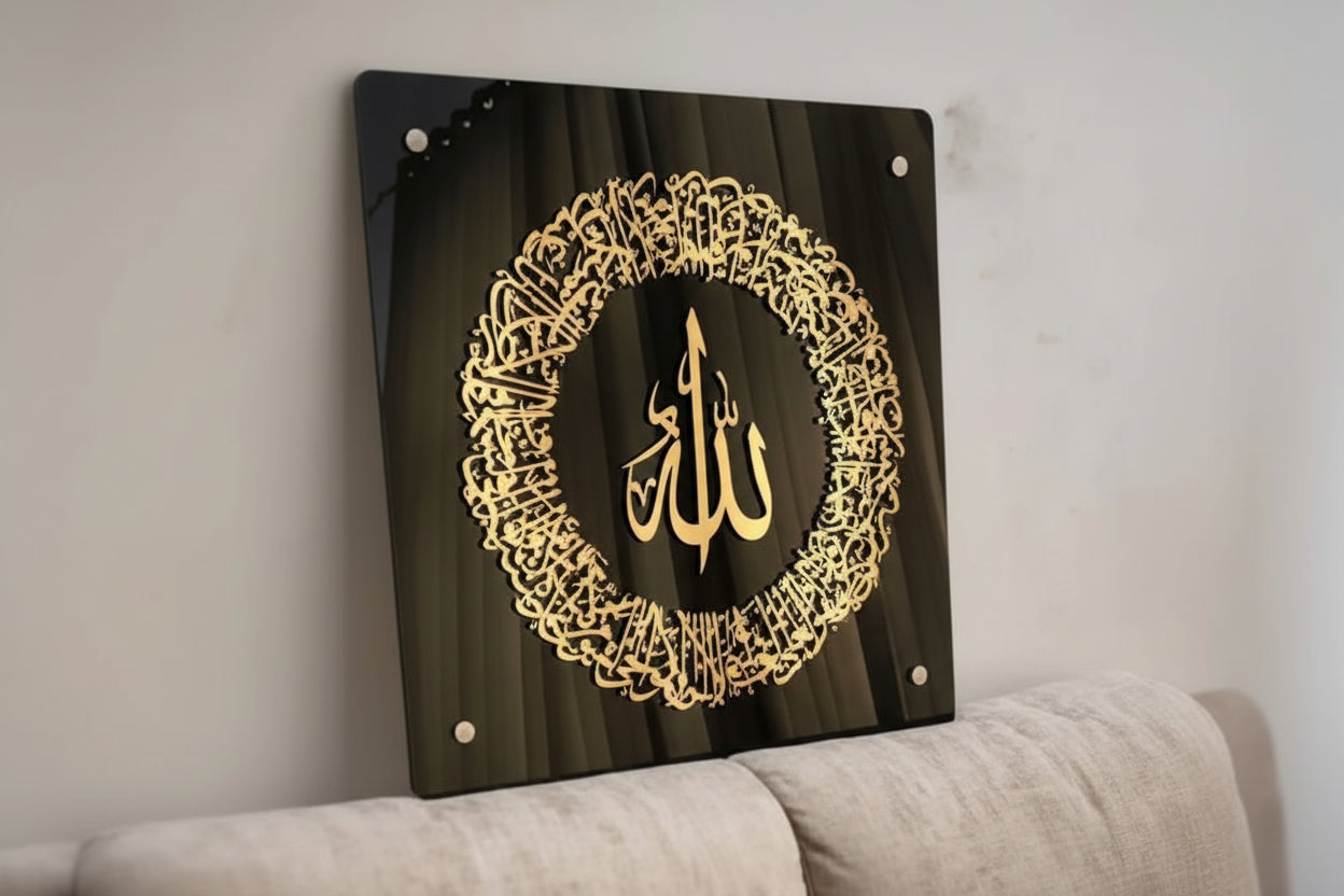 Decorative wall art with 'Allah' in a wreath design on a black background, mounted on a wall above a sofa.