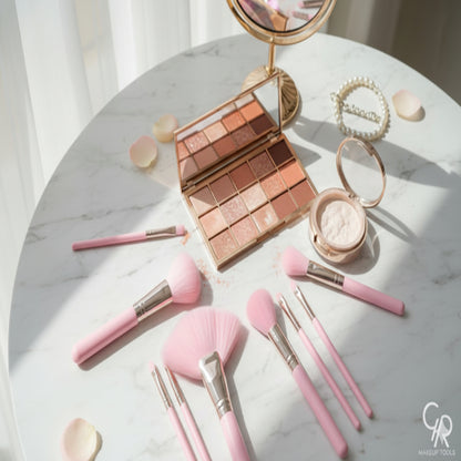 Makeup set with pink brushes and a compact mirror on a marble surface