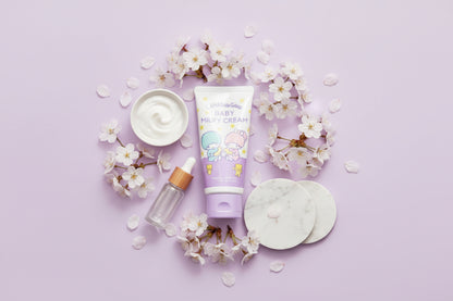 Baby skincare products including a tube of cream, a dropper bottle, and cotton pads on a light purple background with flowers.