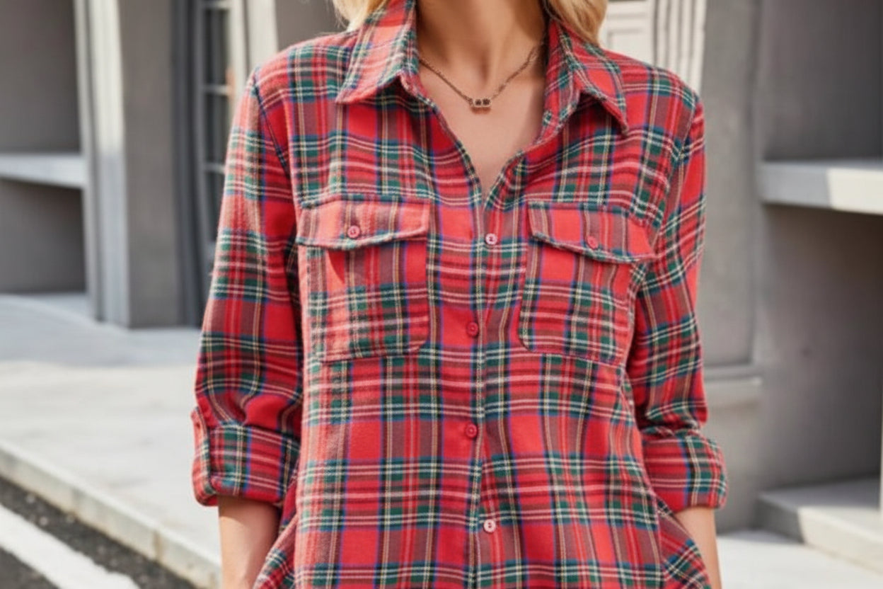 Person wearing a red and green plaid shirt with a neutral background
