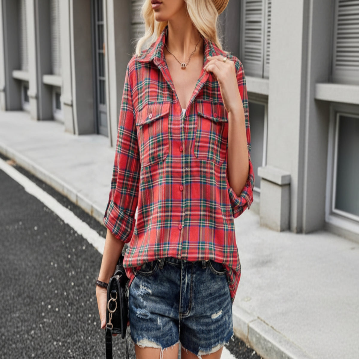 Person wearing a red plaid shirt and denim shorts outdoors.