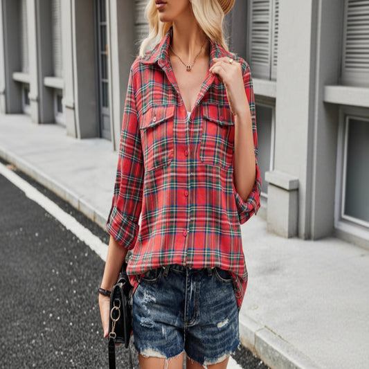 Person wearing a red plaid shirt and denim shorts outdoors.