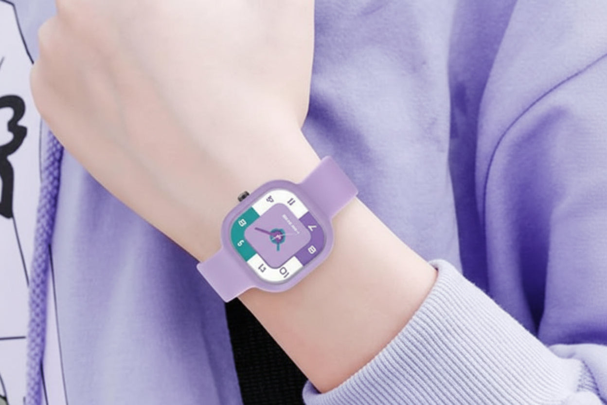 Person wearing a purple watch with a green face on a light purple background