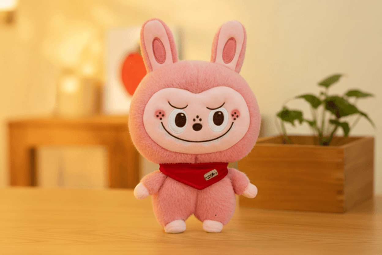 Plush toy with a cartoon face on a wooden surface