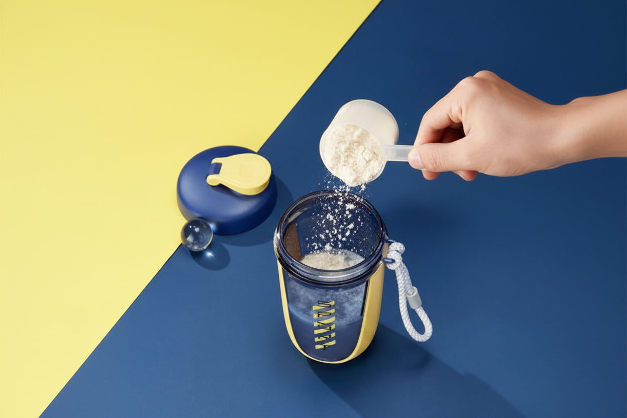 Person adding protein powder to a blue and yellow shaker bottle on a blue and yellow background