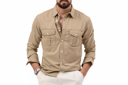 Man wearing a beige button-up shirt with white pants on a white background