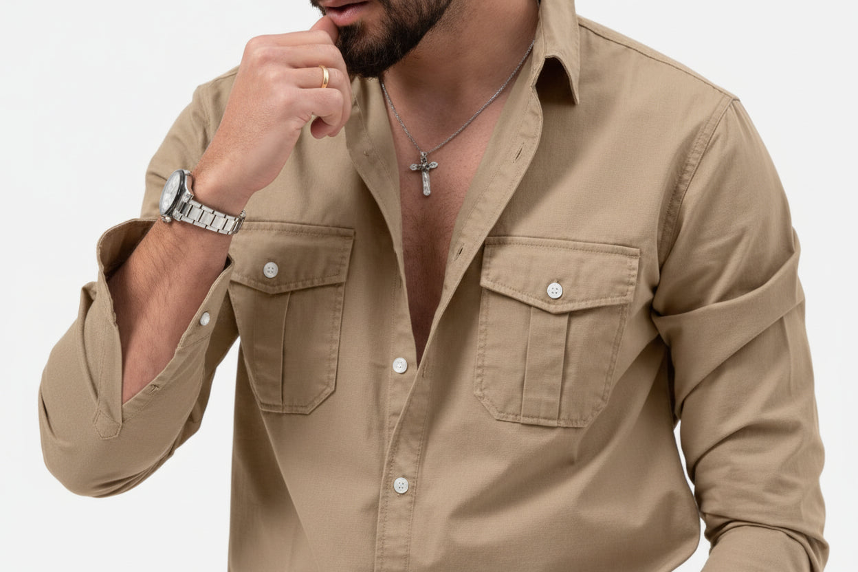 Man wearing a beige shirt with rolled-up sleeves on a white background