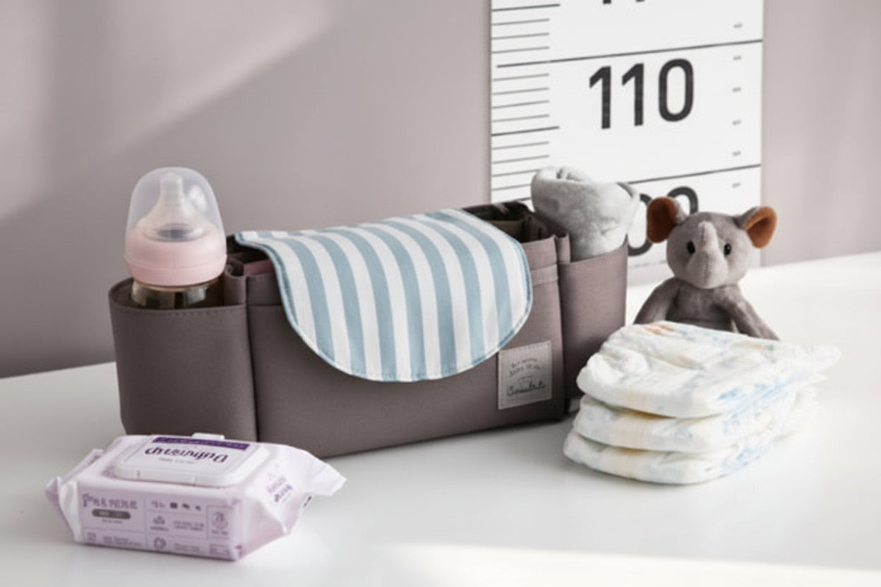 Baby organizer with baby items including a bottle, wipes, and diapers on a white surface.