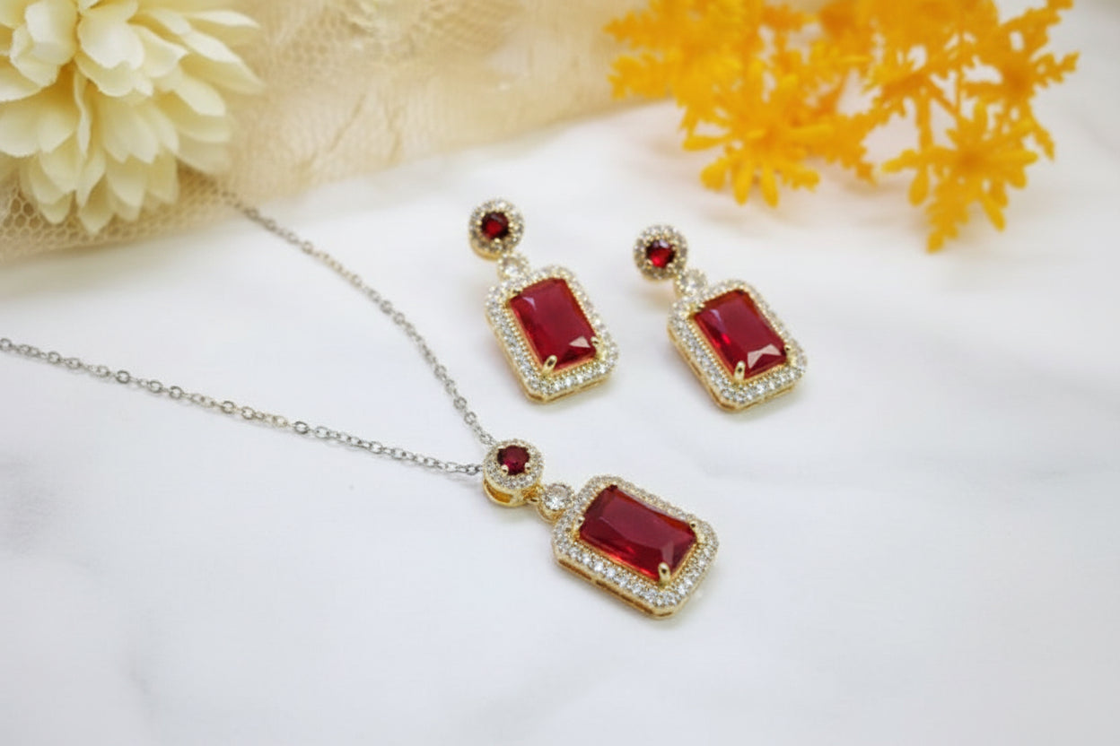 Jewelry set with red gemstones and gold accents on a white background