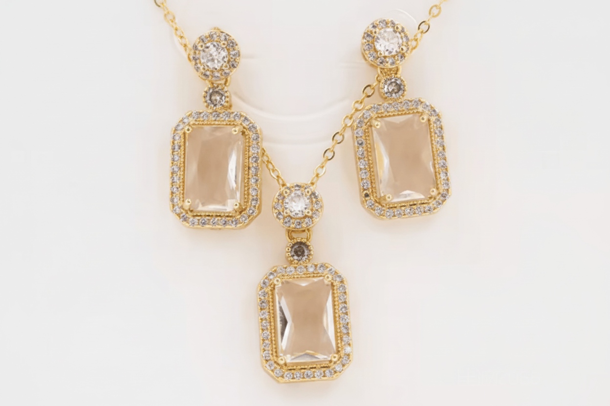 Gold jewelry set with pendant and earrings on a white background
