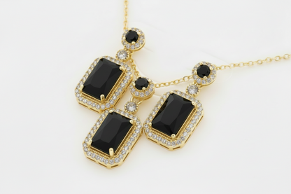 Gold necklace with black gemstones on a white background