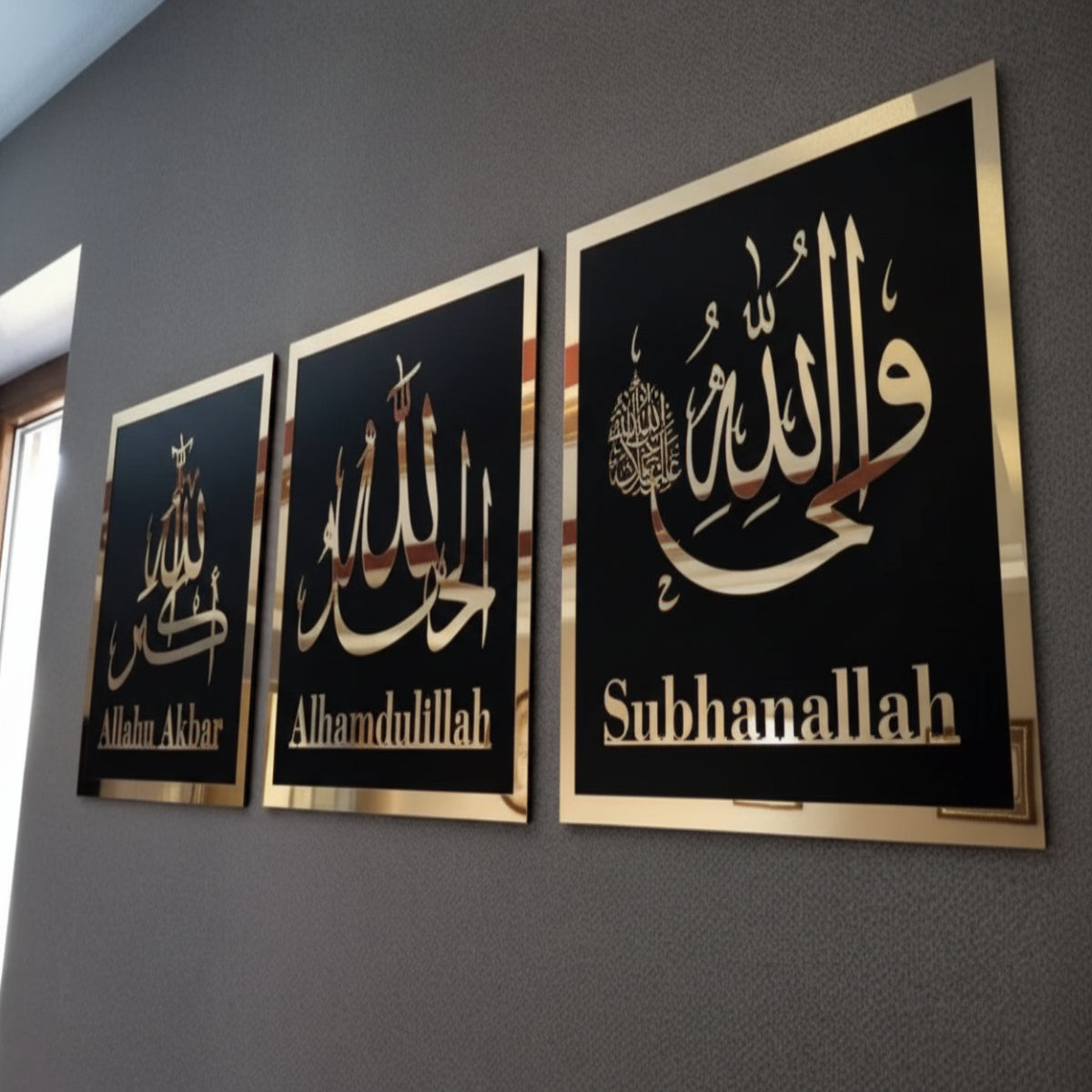 Three framed pieces of art with Arabic calligraphy on a gray wall.