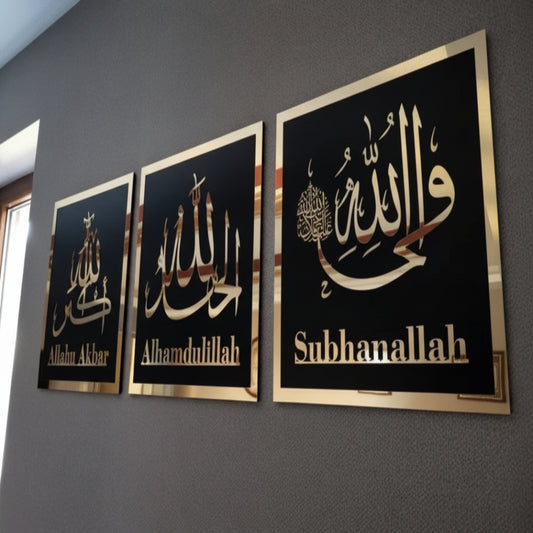 Three framed pieces of art with Arabic calligraphy on a gray wall.