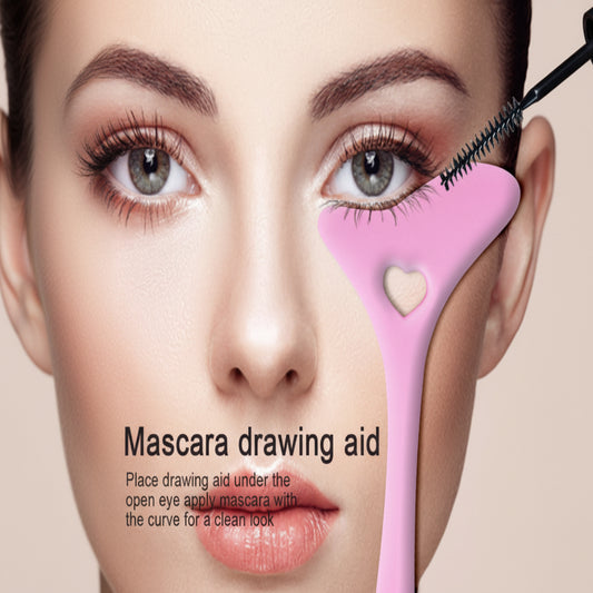 Mascara drawing aid with a heart-shaped guide on a close-up of a person's eye.