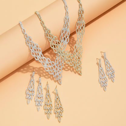 Silver necklace and earrings set on a beige background