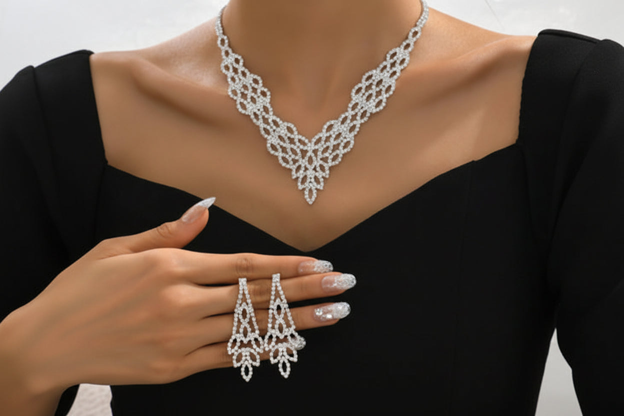Silver necklace, ring, and earrings on a black background