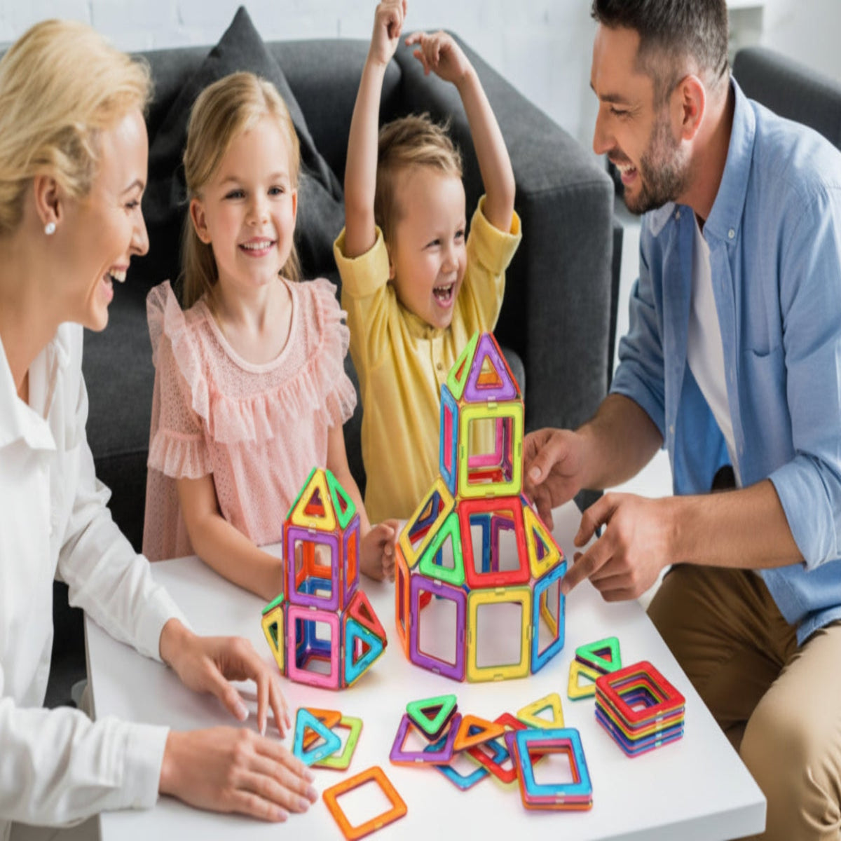 Family playing with colorful magnetic building blocks on a table.