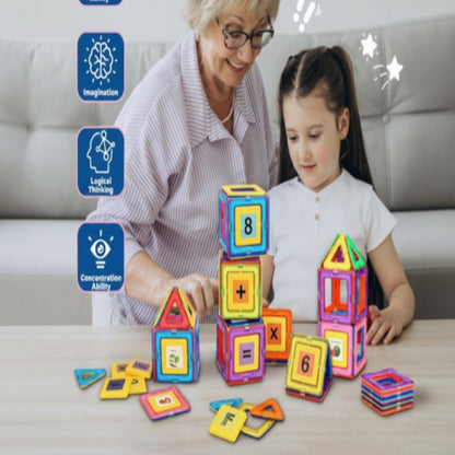 Grandmother and granddaughter playing with colorful magnetic building blocks on a table.