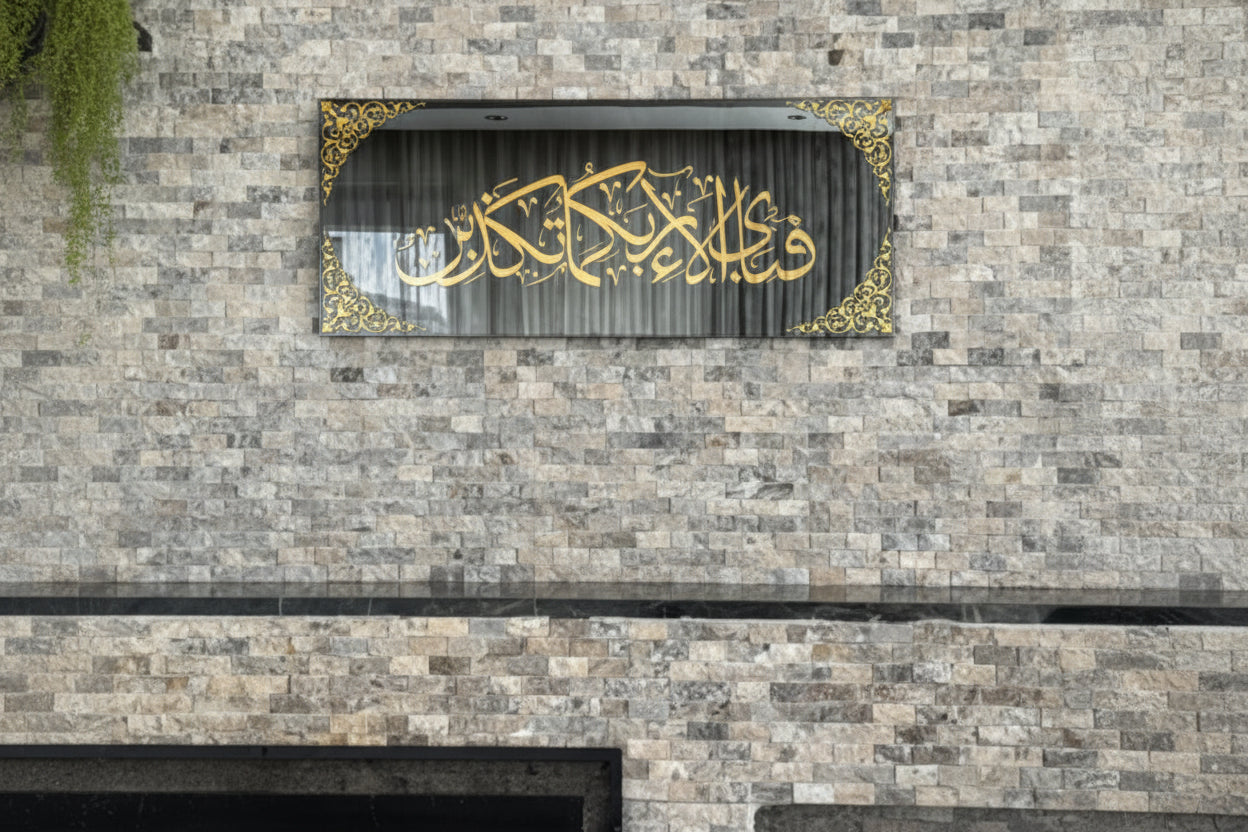Decorative wall art with gold Arabic calligraphy on a stone wall.