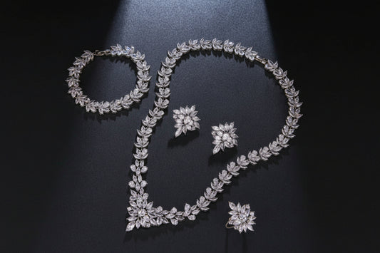 Jewelry set including bracelet, necklace, and earrings on a dark background with measurements.