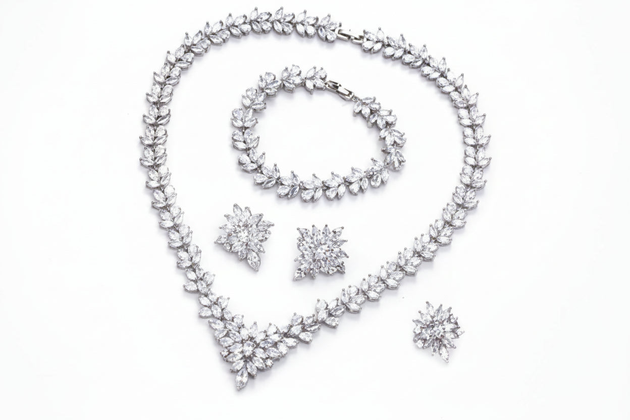 Silver jewelry set with necklace, bracelet, and earrings on a white background