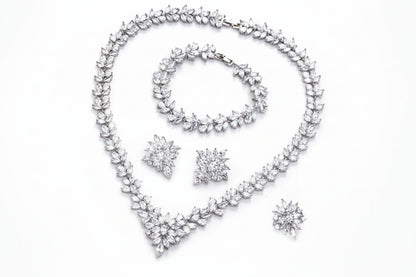 Silver jewelry set with necklace, bracelet, and earrings on a white background